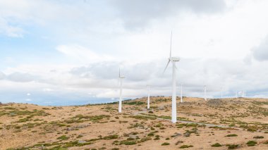 Elektrik Rüzgar değirmenleri Rüzgar tarafından bulutlu gökyüzü arka plan üzerinde taşındı