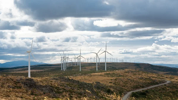 Moinhos de vento elétricos movidos pelo vento sobre fundo céu nublado — Fotografia de Stock