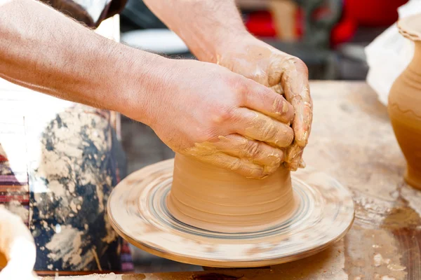 Gros plan des mains travaillant avec de l'argile sur la plaque tournante artisan — Photo