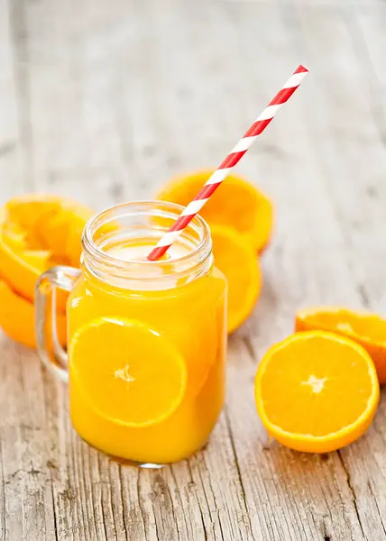 Zumo de naranja exprimido en frasco de vidrio con fondo rústico —  Fotos de Stock