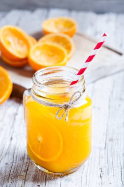 sürahi cam suyu ve saman ile sıkılmış portakal kalıntıları ile