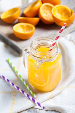 sürahi cam suyu ve saman ile sıkılmış portakal kalıntıları ile