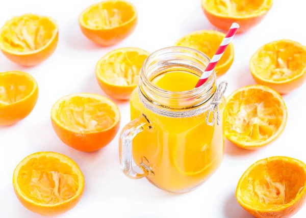 Orangenreste neben vereinzelt auf weißem Orangensaft gepresst — Stockfoto