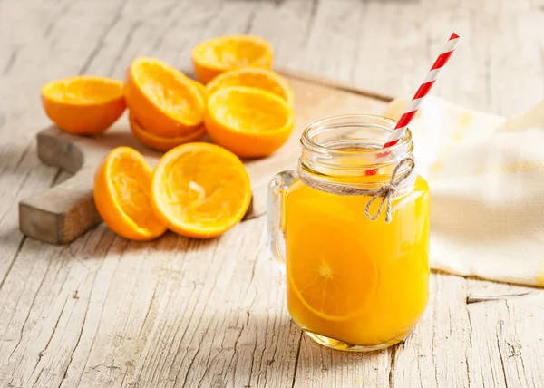 Χυμό πορτοκαλιού σε γυαλί σε ρουστίκ ξύλινο τραπέζι — Φωτογραφία Αρχείου