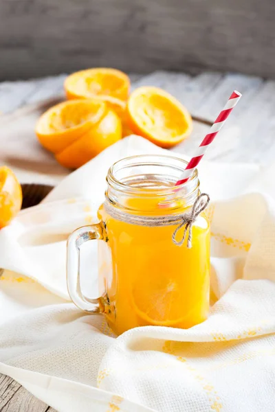 Νόστιμο χυμό πορτοκαλιού πιέζεται στο προσκήνιο σε ποτήρι ja — Φωτογραφία Αρχείου