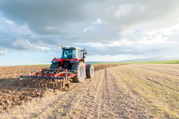 Tractor en el campo en primer plano con el cielo al atardecer — Foto de Stock