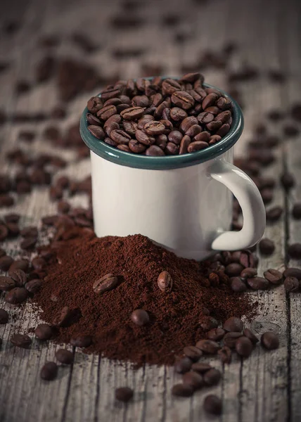 Чашка порцеляни з кавовими зернами на передньому плані в вінтажному стилі — стокове фото