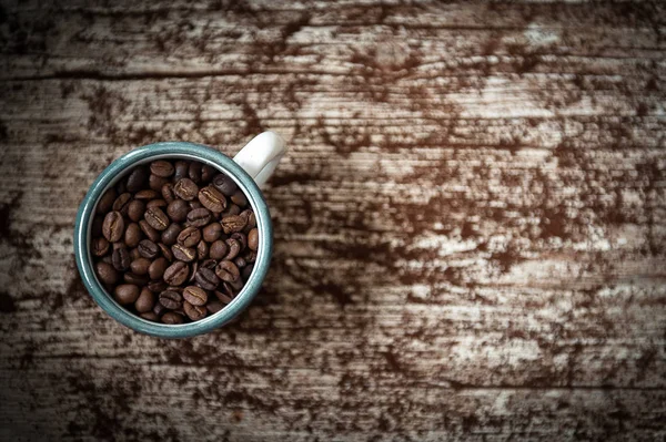 Kopp i porslin med kaffebönor i förgrunden i vintage styl — Stockfoto