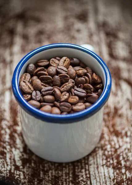 Taza de porcelana con granos de café en primer plano en estilo vintage — Foto de Stock