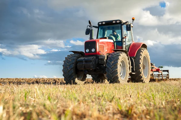 Zemědělský traktor v popředí s modrou oblohou poza — Stock fotografie