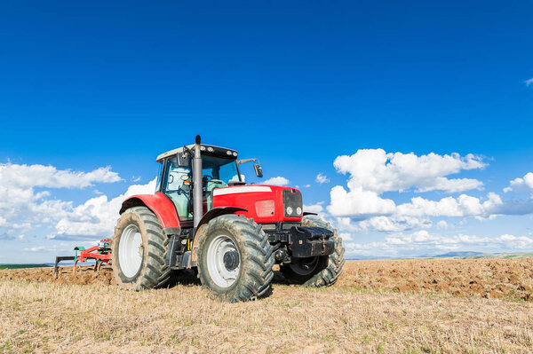 agricultural tractor in the foreground with blue sky backgroun