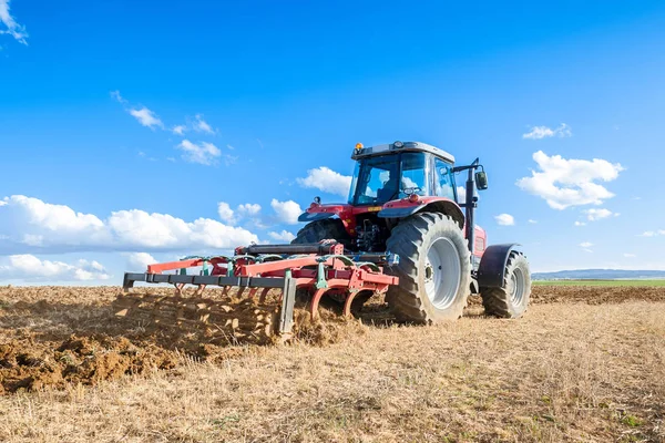 Zemědělský traktor v popředí s modrou oblohou poza — Stock fotografie