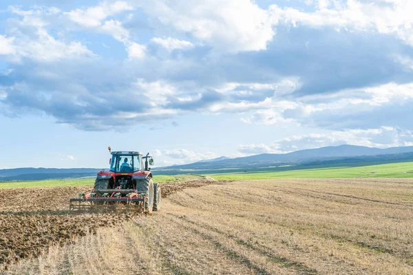Jordbrukstraktor i förgrunden med blå himmel bakgrund — Stockfoto
