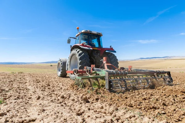 Landbrukstraktor i forgrunnen med blå himmel i ryggen – stockfoto