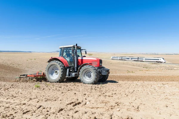 Landbrugstraktor i forgrunden med blå himmel baggrund - Stock-foto