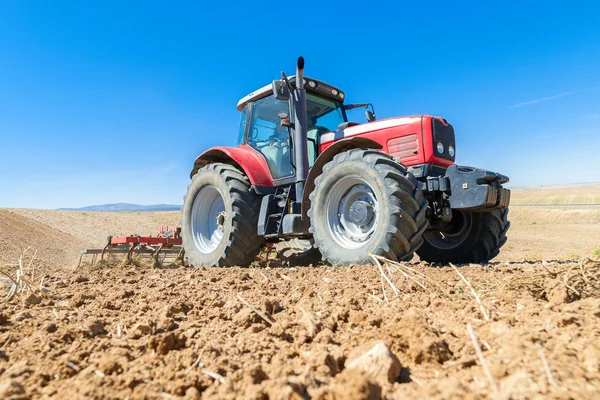 Сельскохозяйственный трактор на переднем плане с голубым небом backgroun — стоковое фото