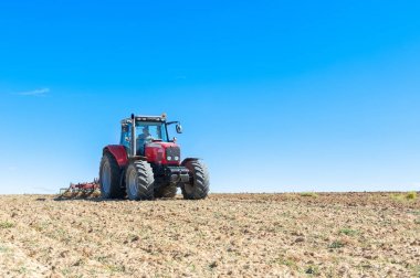 Mavi gökyüzü adam ile ön planda tarım traktör