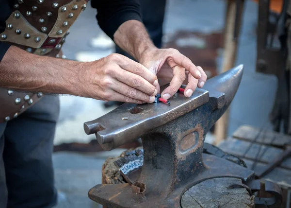 Blacksmith working the metal on Anvil in the foregroun — Stock Photo, Image