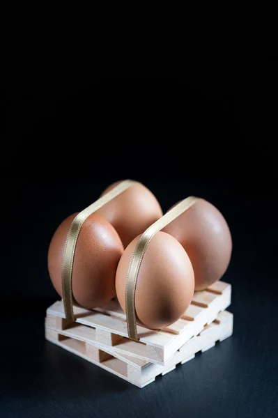 Huevos de gallina atados con correas en pala de madera — Foto de Stock