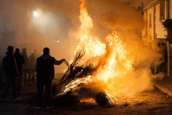 Traditio kutlamak için dalları sokakta yanan genç adam