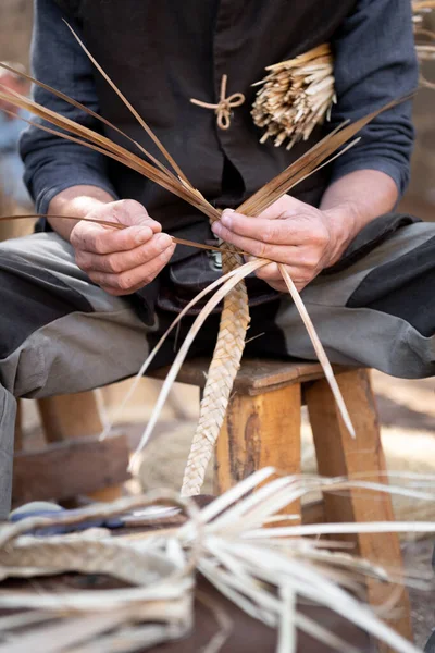 Старый плетеный ремесленник с руками, работающими в изолированной foregroun — стоковое фото