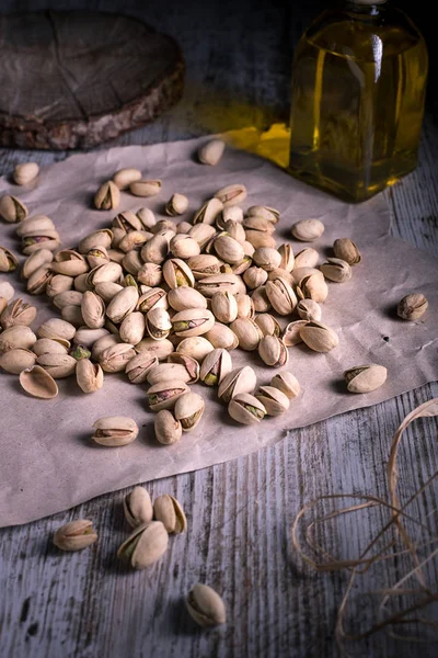 pistachios on wooden table in the foreground with darkened backgroun