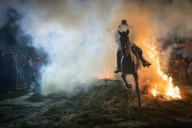 Ocak 'ta İspanya' nın Avila kentindeki El Herradn de Pinares kasabasında düzenlenen dini bir etkinlikte, atını süren, hayvanı arındırmak için attan atlayan, ateşten atlayan kişi,
