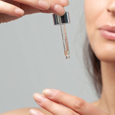 Pipetli genç kadının elleri. Cilt bakımı ve yaş kozmetik