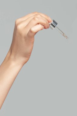 Pipetli genç kadının elleri. Cilt bakımı ve yaş kozmetik