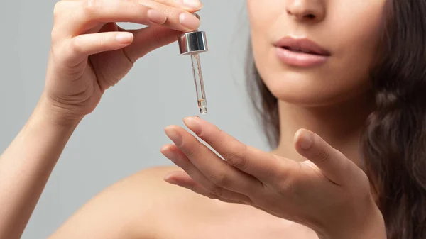 Pipetli genç kadının elleri. Cilt bakımı ve yaş kozmetik