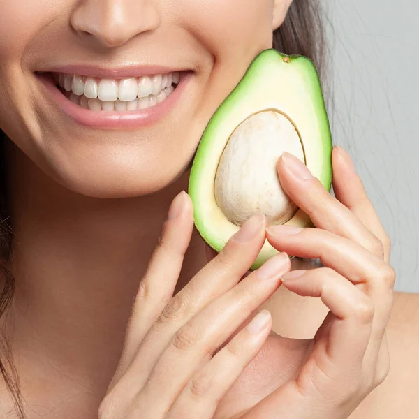 Avokado tutan genç ve güzel bir kadın. Güzellik, gençlik, cilt bakımı