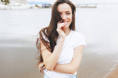 Genç, güzel, mutlu bir kadın marinada sahilde yürüyor. Pozitif, seyahat, özgürlük. Avrupa