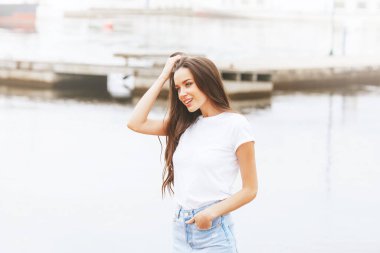 Genç, güzel, mutlu bir kadın marinada sahilde yürüyor. Pozitif, seyahat, özgürlük. Avrupa