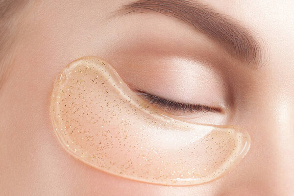 Молодая красивая женщина с чистой идеальной кожей с косметическими пятнами на лице крупным планом. Портрет красоты
