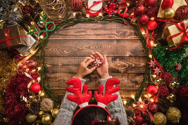 Chica que pone la composición plana de Navidad en el fondo de madera con espacio de copia para su texto. Feliz Navidad y Feliz Año Nuevo . — Foto de Stock