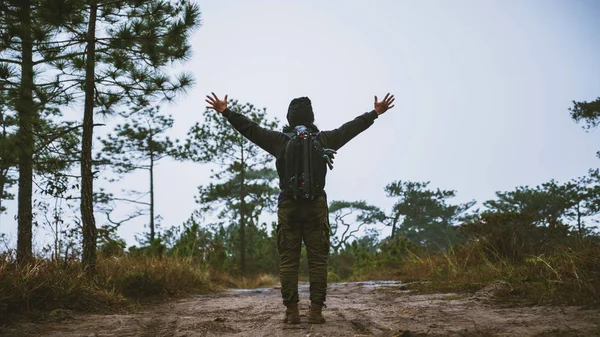 Asian men Travel Nature. Travel relax. Standing natural touch grass on the Mountain. man with a backpack Walking in the grass forest. travel nature. Hiking — Stock Photo, Image