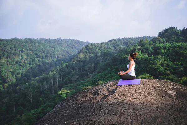 Az ázsiai nők lazítanak az ünnepekkor. Játssz, ha jógázol. A hegyi sziklaszirten. Természet hegyi erdők Thaiföldön. Fiatal nő jógázik a természet női boldogságában. jóga testmozgás — Stock Fotó