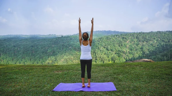 Азиатские женщины отдыхают в праздник. Играй, если йога. На скале в горах. Природа горных лесов в Таиланде. Молодая женщина практикует йогу в природе женского счастья. упражнения йоги — стоковое фото