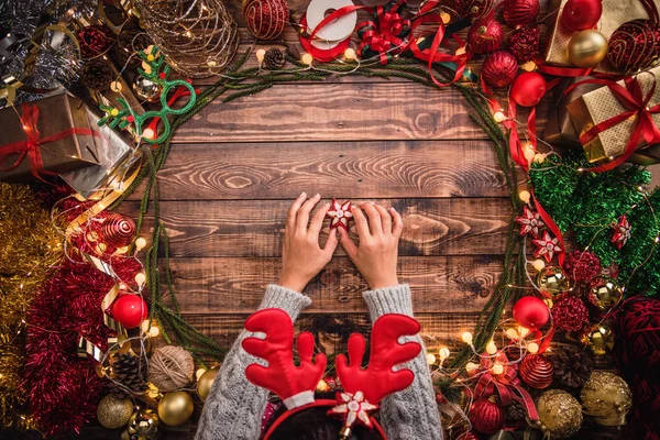Chica que pone la composición plana de Navidad en el fondo de madera con espacio de copia para su texto. Feliz Navidad y Feliz Año Nuevo . — Foto de Stock