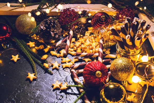 Bolas de decoración navideña con galletas y pasteles sobre fondo abstracto bokeh negro con espacio para copiar y luces led decorativas. Feliz Navidad y Año Nuevo. tarjeta de felicitación . — Foto de Stock