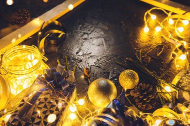 Mavi kurdeleli Noel hediyesi ve soyut bokeh siyah arkaplanlı süsleme topları fotokopi alanı ve dekoratif ışıklı. Mutlu Noeller ve yeni yıl.