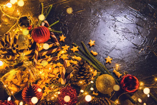 Bolas de decoración navideña con galletas y pasteles sobre fondo abstracto bokeh negro con espacio para copiar y luces led decorativas. Feliz Navidad y Año Nuevo. tarjeta de felicitación . — Foto de Stock