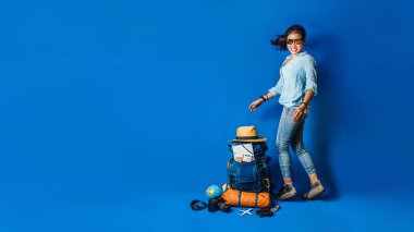 Young Asian traveler happy woman in Blue shirt with backpack with and equipment for travelers Vacation with a map