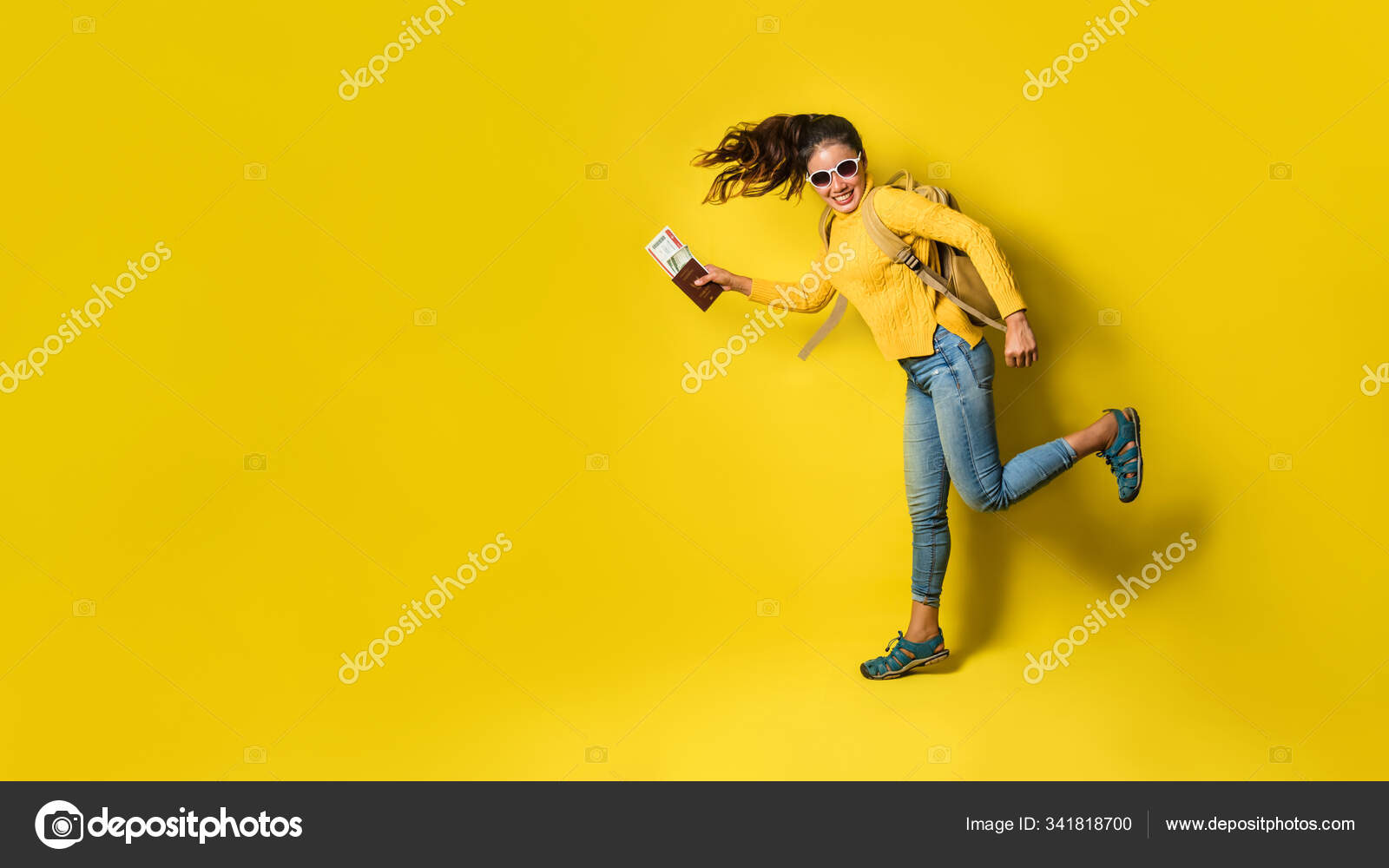 带着手提箱的女旅行家 持有黄色背景的护照 穿着黄色衣服的快乐女孩的画像 图库照片 C Last19