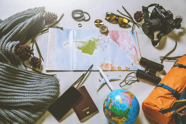 Tourist planning vacation with the help of world map with other travel accessories around. smartphone, — Stock Photo, Image