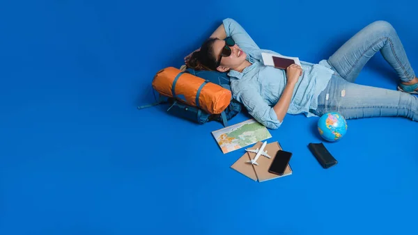 Touristische Planung Urlaub mit Hilfe von Weltkarte mit anderen Reise-Accessoires herum. Frau schläft entspannt in der Hand haltend — Stockfoto