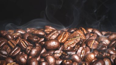 Brown roasted coffee beans seed on dark background clipart
