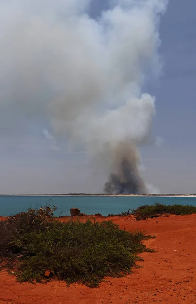 BROOME, AUSTRÁLIA OCIDENTAL / AUSTRÁLIA - 26 DE SETEMBRO DE 2019: vista da paisagem da coluna de fumaça que sobe do fogo do mato ao norte da praia de cabos Imagens De Bancos De Imagens