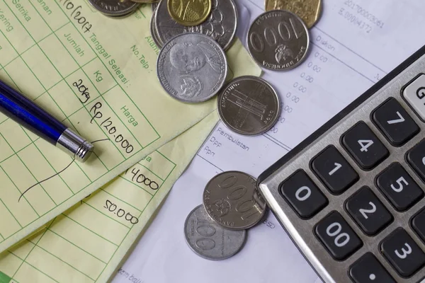 Endonezya Rupiahı ve Singapur Doları paralar, hesap makinesi ve fatura ile ödeme makbuzu hesaplama