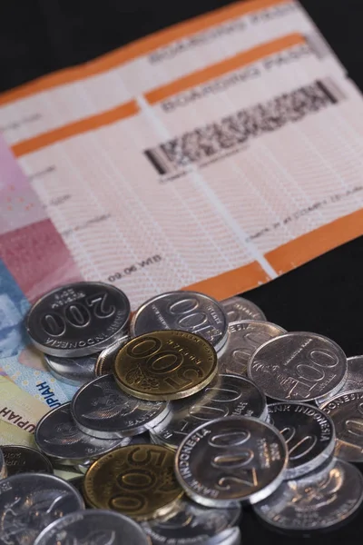 Illustration for Spending money for holiday and payment for travel, boarding pass in isolated black focused at coins/money